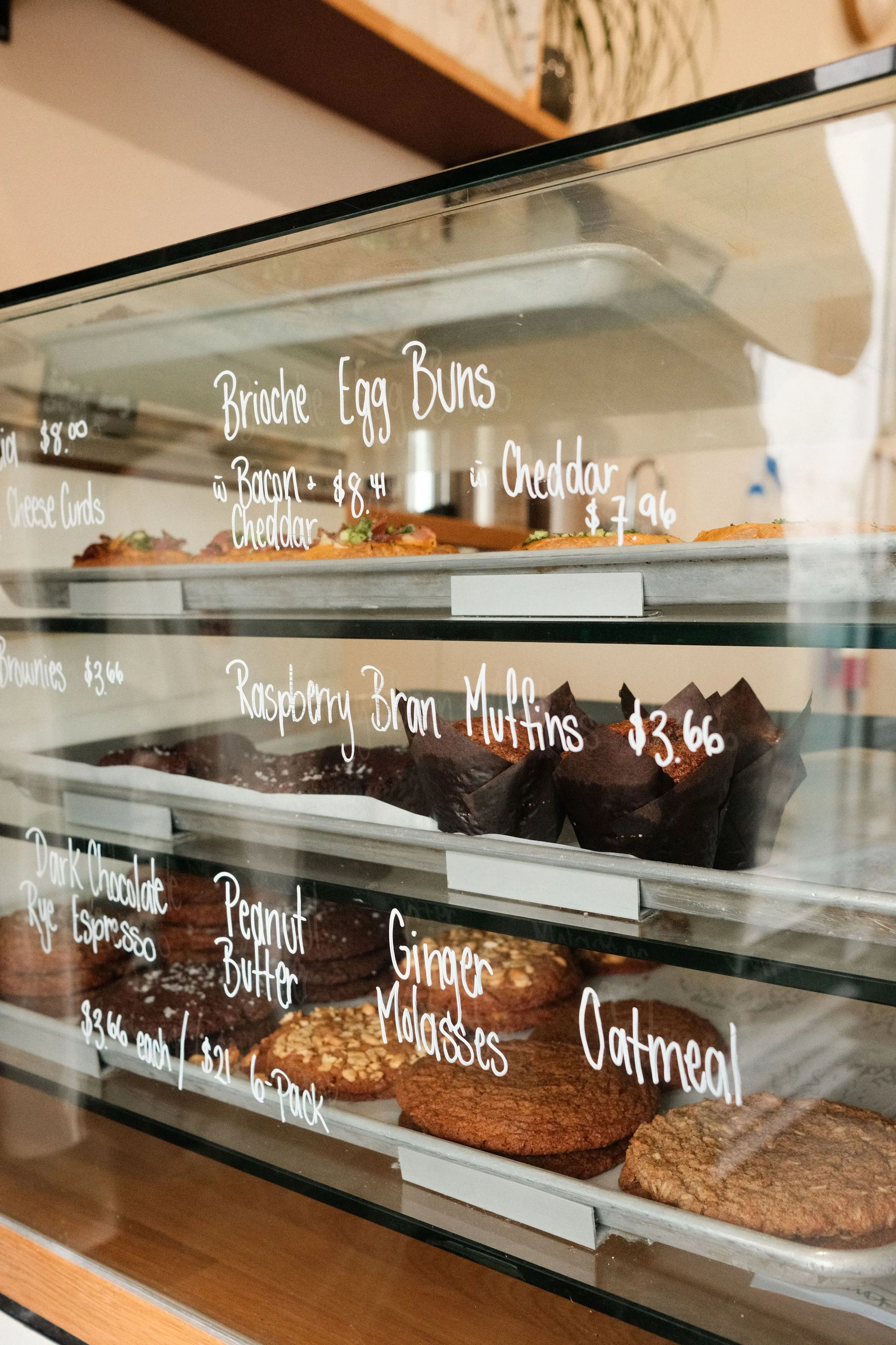 A display case with baked goods inside and writing on the outside